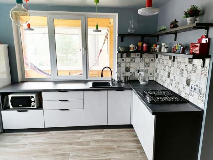 Современная угловая кухня без верхних навесных шкафов в загородный дом - фото - 1