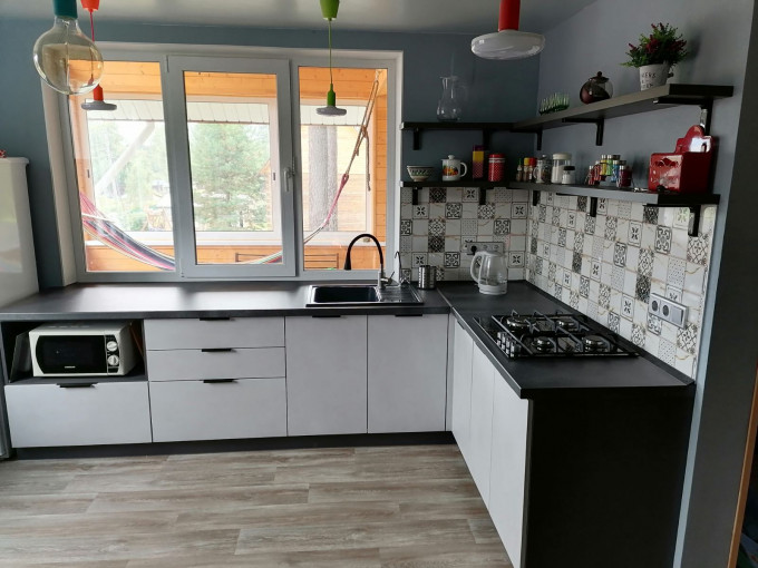 Современная угловая кухня без верхних навесных шкафов в загородный дом - фото - 2