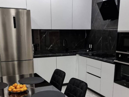 Белая угловая кухня с контрастной черной рабочей зоной - фото - 1